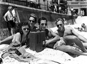 A group of young friends listens to the radio and sunbakes at Bondi Beach, Sydney. 19 December, 1948