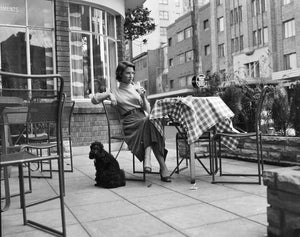 Miss Diana Fuller seated at a table with her dog at the Rex Hotel in Kings Cross. 14 September 1954.